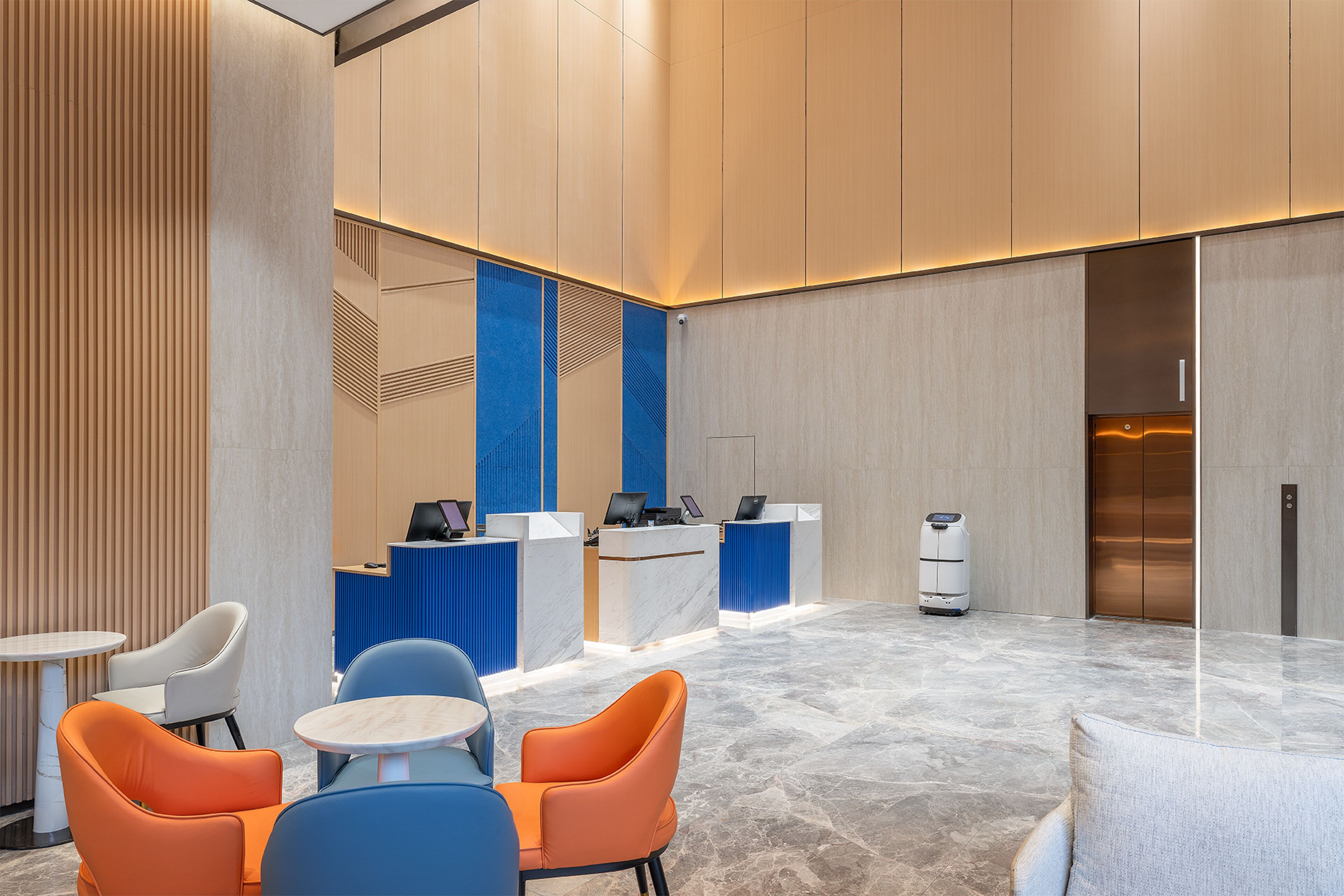 Un área de recepción moderna con suelo de mármol, mostrador de recepción y zonas de estar.