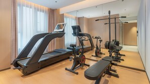 A modern hotel gym with a treadmill, stationary bike, and weight bench. - Holiday Inn Express Changsha Yuhua by IHG (Changsha)