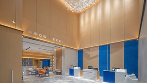 A modern hotel lobby with a reception desk, seating area, and a decorative ceiling feature. - Holiday Inn Express Changsha Yuhua by IHG (Changsha)