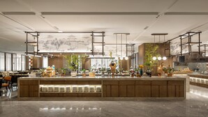 Un restaurante moderno con una isla central, paneles de madera y luces colgantes.