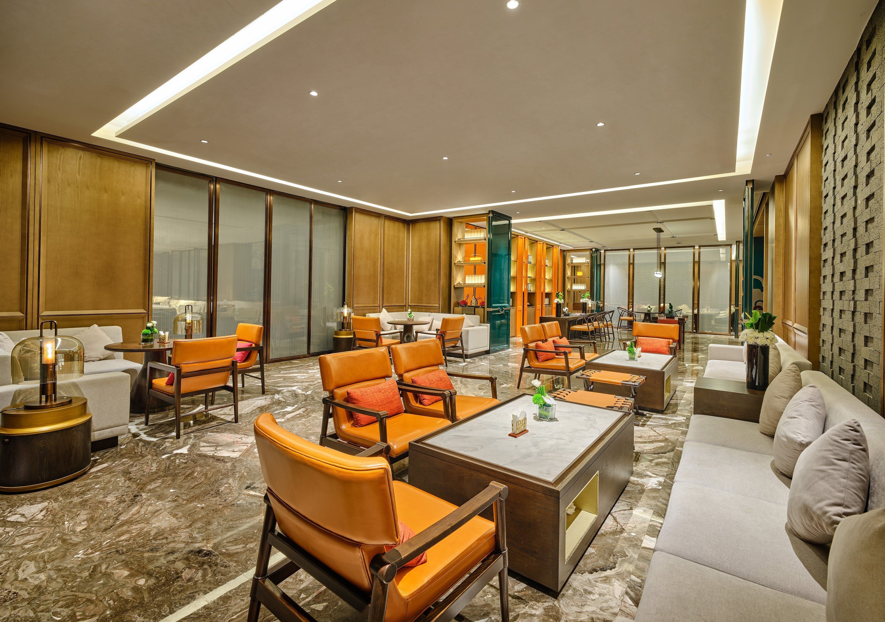 A spacious hotel lobby with leather armchairs, sofas, and a coffee table.