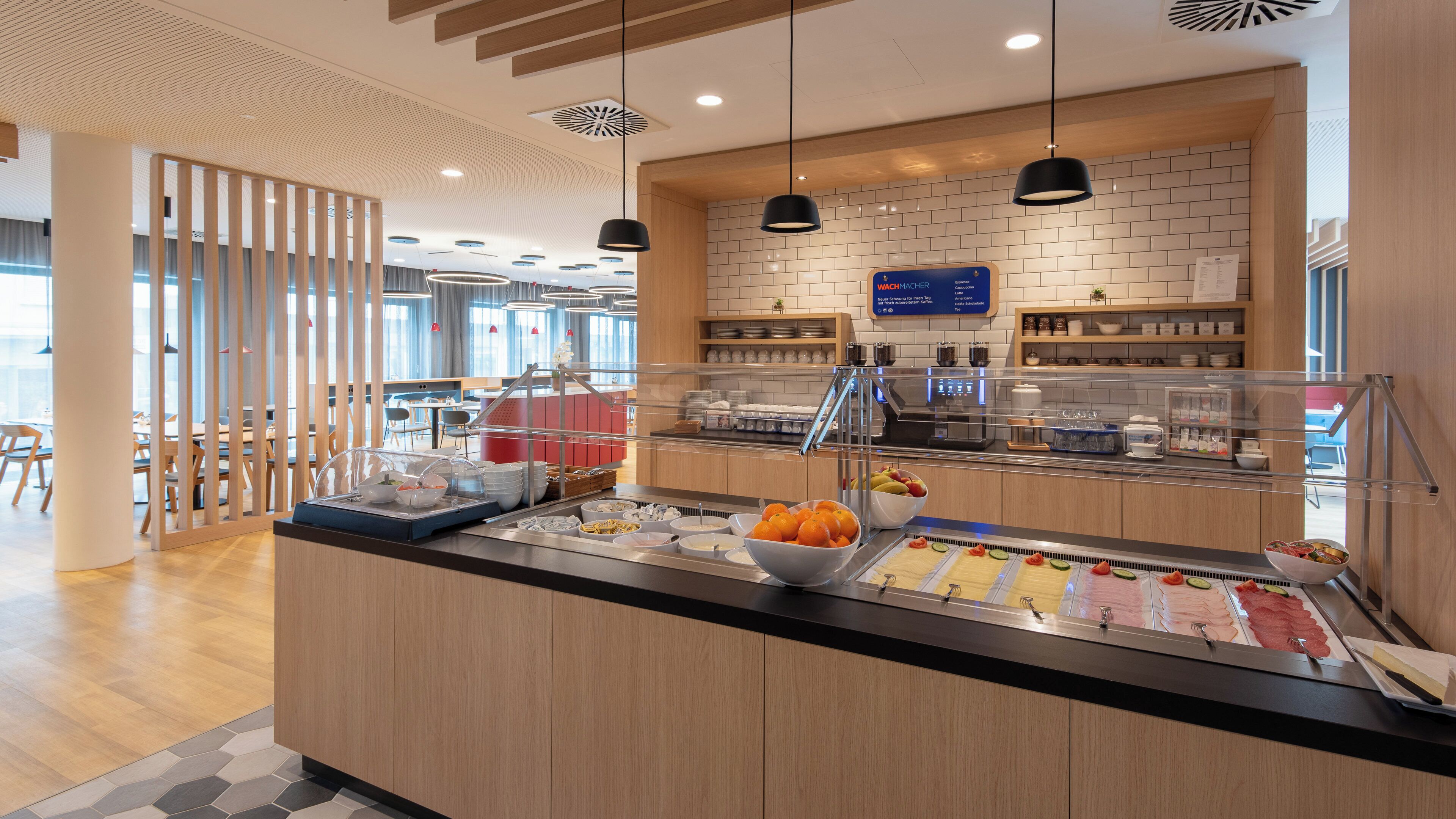 A modern breakfast bar with a variety of food items, including fruits and pastries, and a coffee station with a menu sign above.