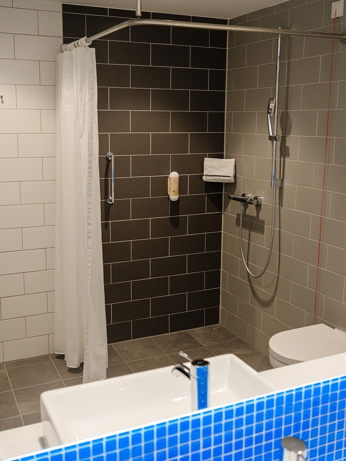 A bathroom with a shower, toilet, and sink.
