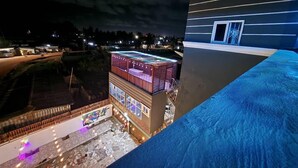 A modern building with a flat roof, large windows, and a balcony area with outdoor lighting. - 696 Arena Aflao (Aflao)