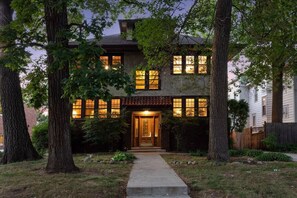 A two-story house with a central entrance, surrounded by trees and a well-maintained lawn. - Footsteps to Lake Harriet! 1 Block to Restaurants! (Minneapolis)