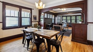 A spacious dining area with a wooden table and chairs, large windows with blinds, and a view of the outdoors. - Just A Short Stroll to Lake Harriet & Restaurants! (Minneapolis)