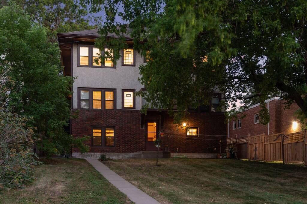 A two-story house with a brick facade and multiple windows.