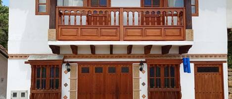 Traditional building with a wooden balcony and stone base.