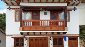 A two-story building with a balcony, wooden doors, and windows. - CASA HOTEL LA VILLA DEL ROSARIO (Villa de Leyva)