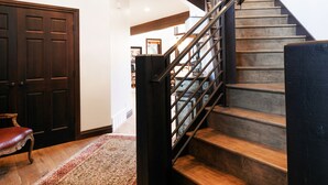 Una escalera de madera con barandillas de metal que conduce a un nivel superior.