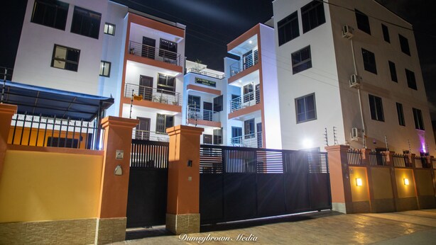 A multi-story building with balconies and a gated entrance.