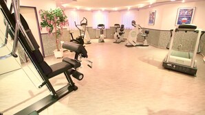 A gym with various exercise equipment, including treadmills, stationary bikes, and weight machines.