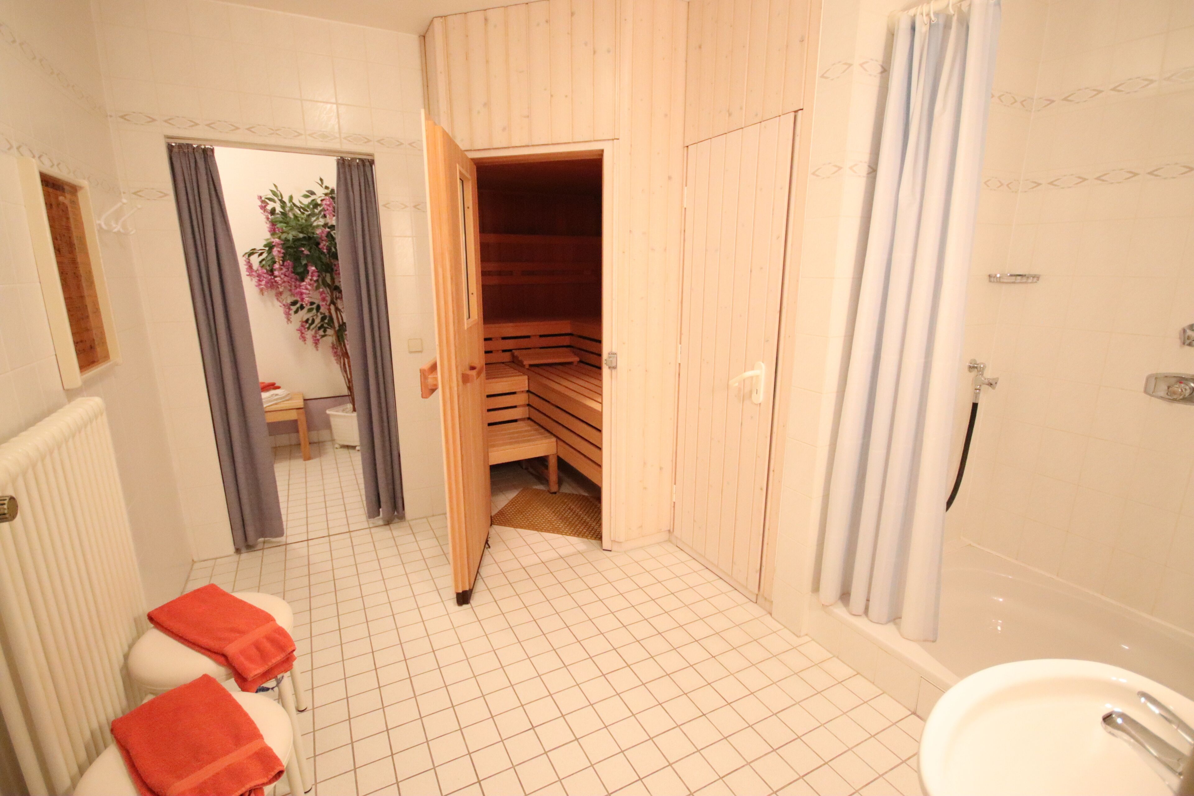 Ein Badezimmer mit Holzzimmer, einer Badewanne und einem Waschbecken.