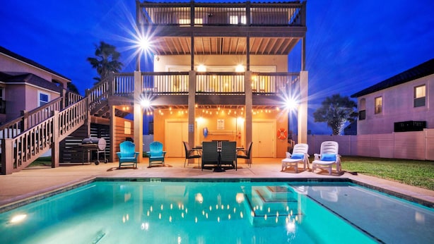 A two-story building with a pool, outdoor seating, and a barbecue area. - Boots & Beaches Avantstay Golf Cart Access, Brd Walk (Port Aransas)