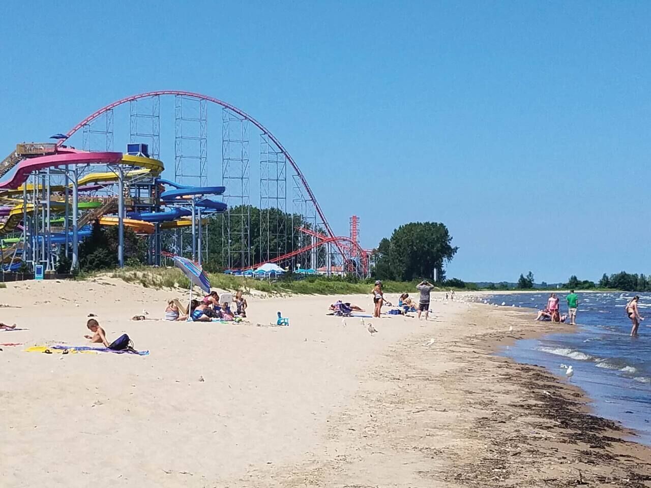 Une plage avec des montagnes russes en arrière-plan.