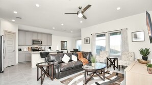 A modern living room with a leather sofa, coffee table, and a dining area with a wooden table and chairs. - Exquisite 3 bedroom house located in a very quiet area of Katy . (Katy)