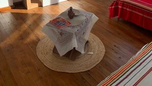 A room with a wooden desk, a small table with a newspaper, a red bed, and a window with a view of greenery. - House Sleeps 6-garden-freeparking-bbq-patio-petsok (Karnobat)