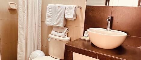 A bathroom with a toilet, sink, and shower curtain.