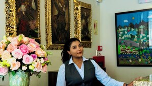 Una recepción con un arreglo floral, obras de arte enmarcadas y un cuadro en la pared.