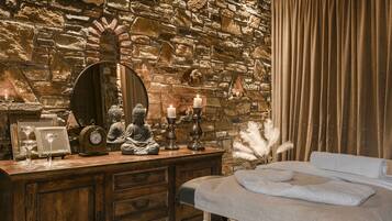Cozy retreat with a rustic stone wall, wooden dresser, and inviting bed.