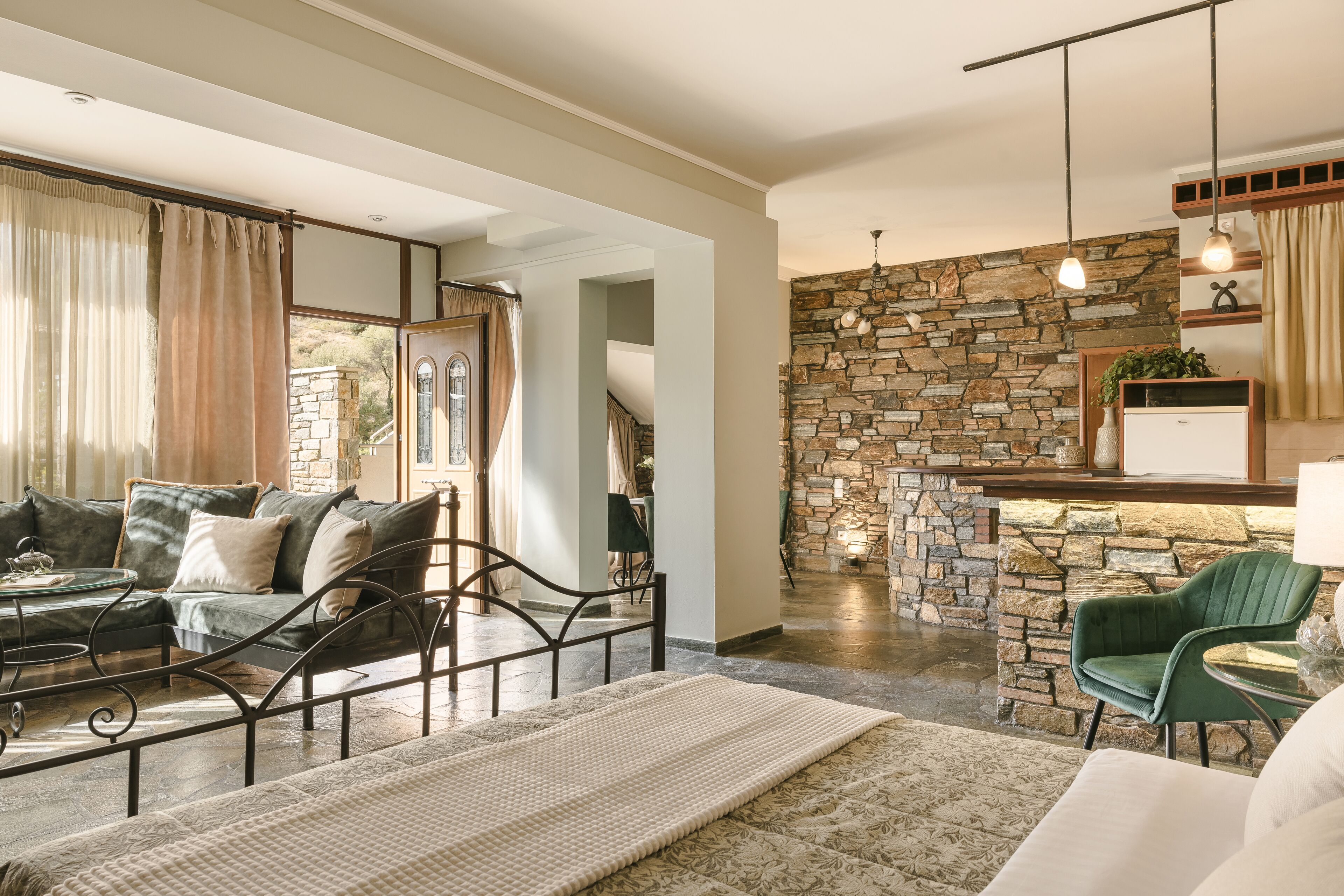 A modern living room with a stone accent wall, a green armchair, and a glass coffee table.