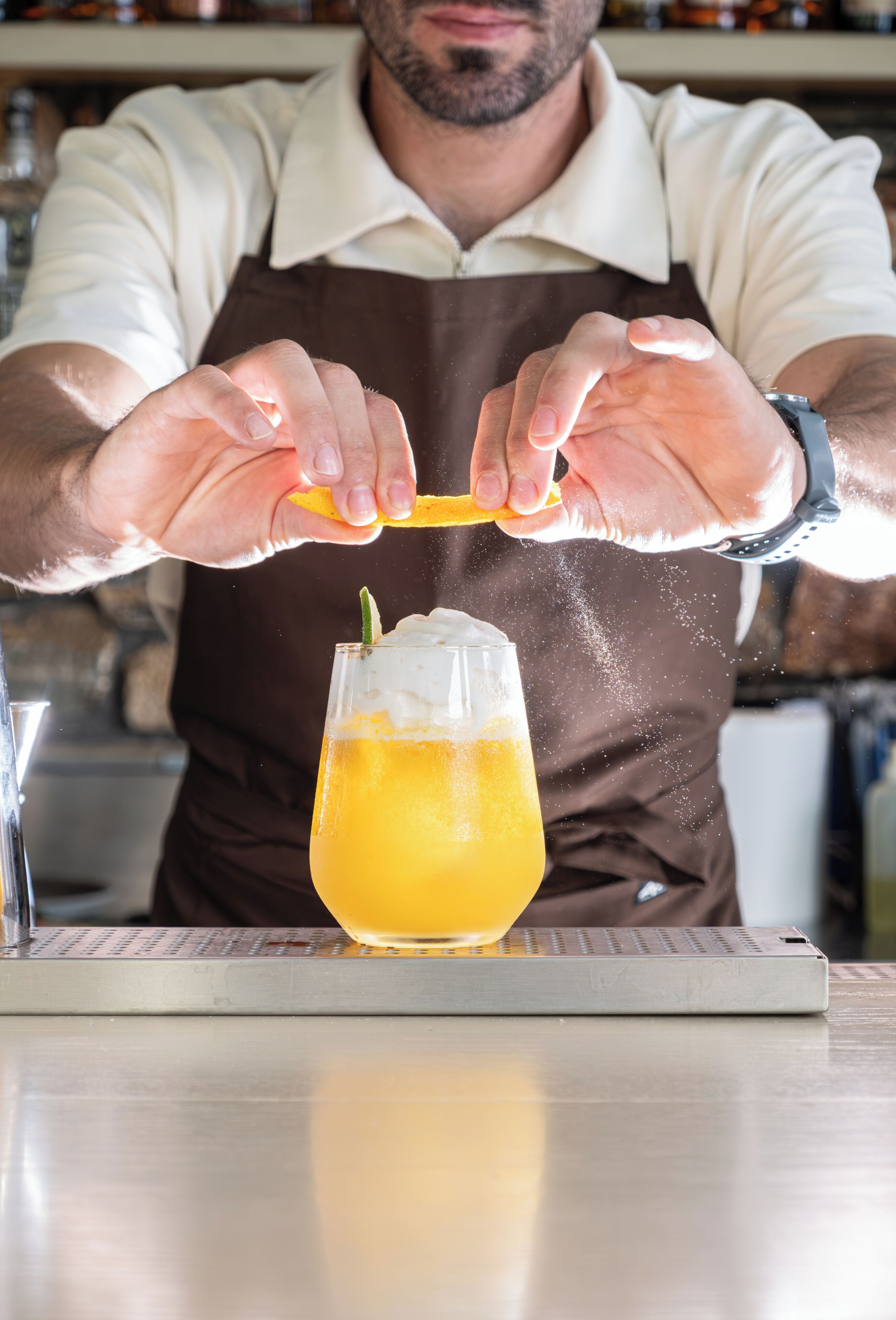 Eine Person presst eine Zitrone über ein Glas Orangensaft.