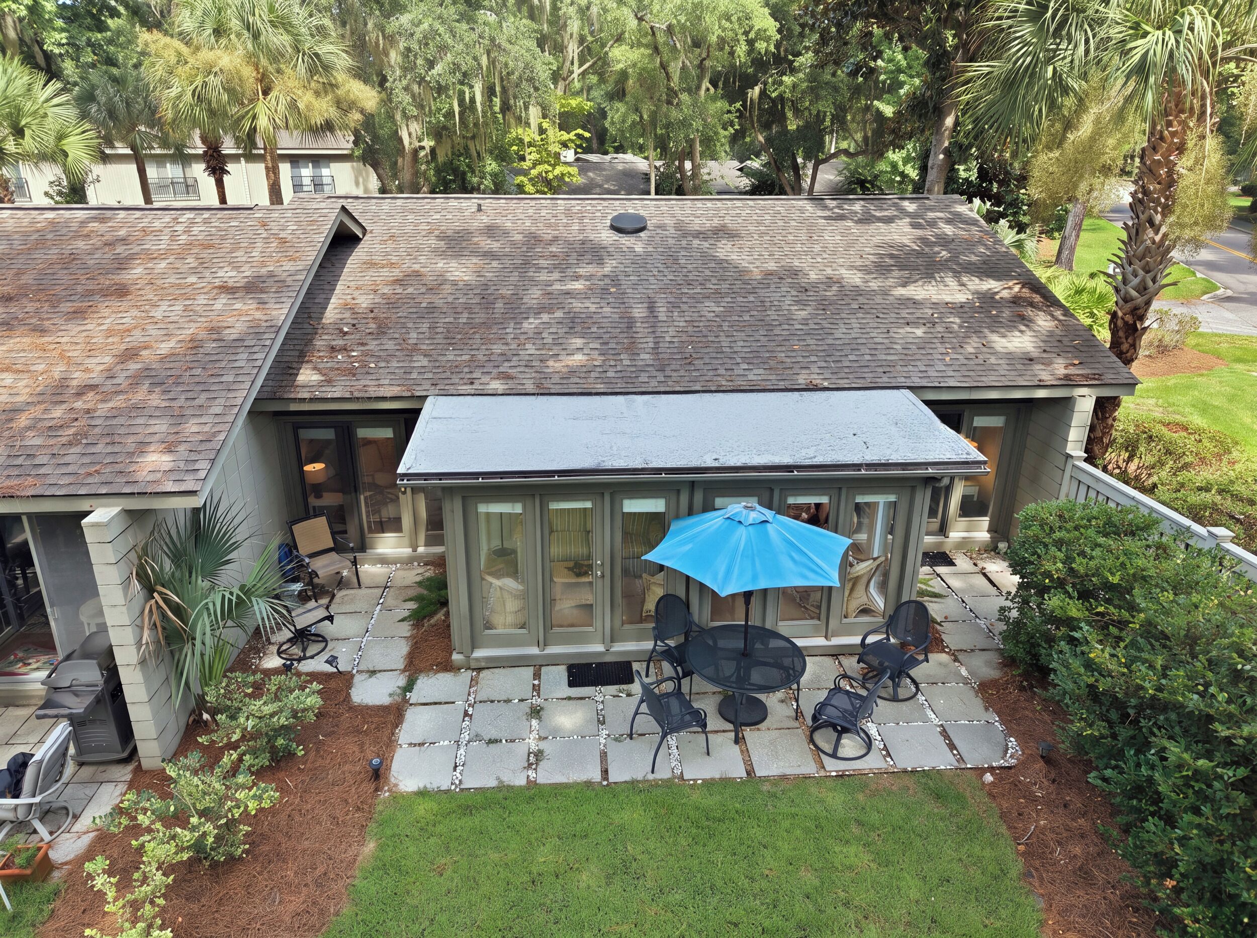 A house with a covered patio, outdoor seating, and a lawn.