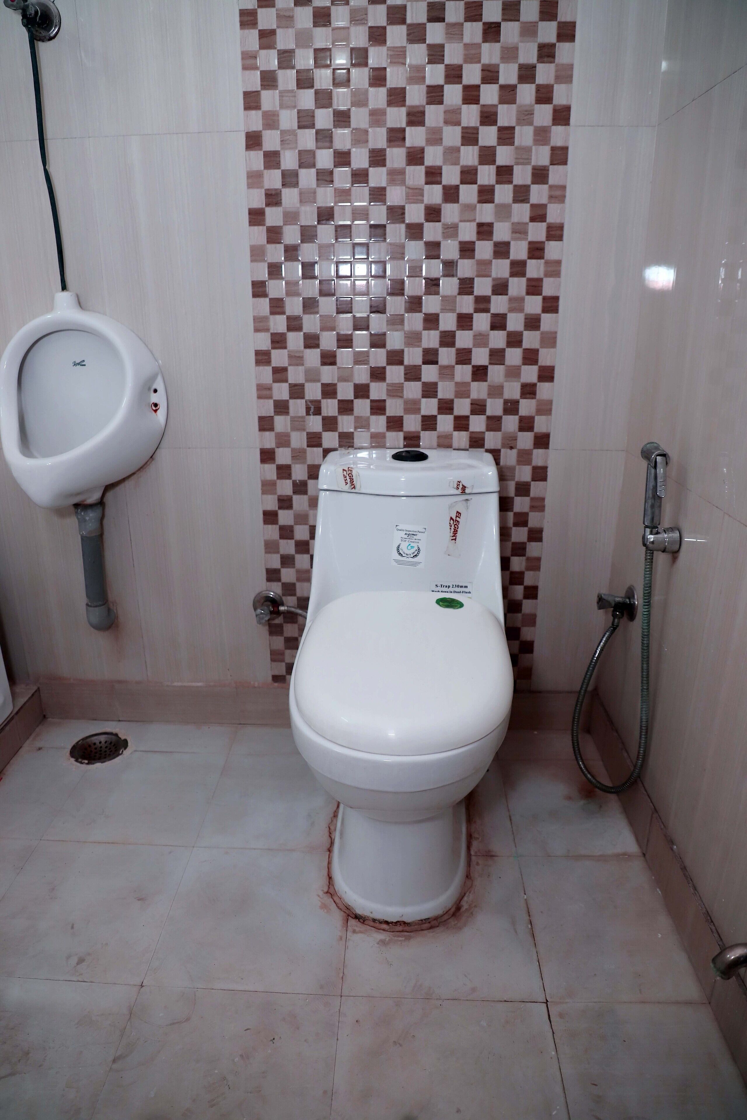 Un baño con inodoro, orinal y ducha.