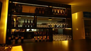 A bar area with shelves of bottles and glasses.