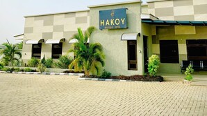 A boutique hotel named Hakoy with a modern design, featuring a paved entrance area and well-maintained landscaping.
