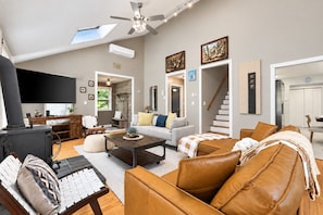 A spacious living room with a fireplace, a sofa set, a coffee table, and a television.