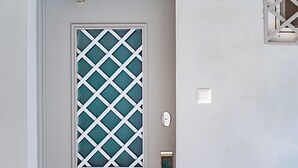 A door with a geometric pattern, a keypad lock, and a light fixture above it. - H&B apartments Ierusalim (Tbilisi)