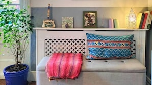 A cozy living room with a sofa, a potted plant, and wall art. - Charming London With Balcony (London)