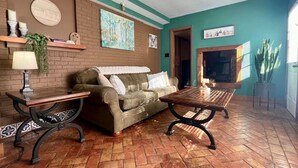 Ein Wohnzimmer mit einer Couch, einem Couchtisch, einer Lampe und einem Kamin.