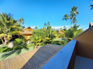A resort with a pool, palm trees, and a wooden deck.