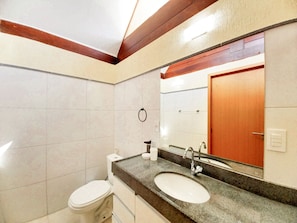 A bathroom with a toilet, sink, and mirror. - Lindos Bangalôs no Eco Resort  (Tamandaré)