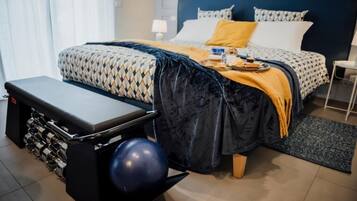 Une chambre à coucher bien rangée, avec un lit, une table de chevet et un banc avec des poids.