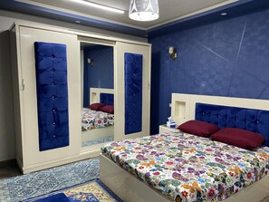 A bedroom with a bed, a wardrobe, and a nightstand. - comfortable and relaxed apartment (محافظة أسيوط)