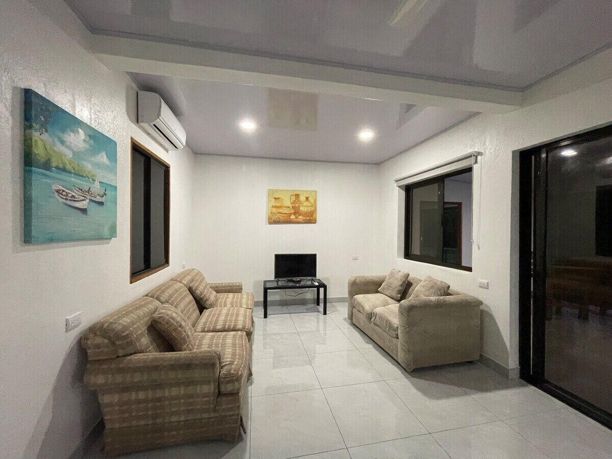 A living room with two sofas, a flat-screen TV, and artwork on the walls.