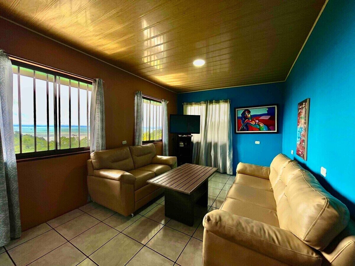 A living room with two beige sofas, a wooden coffee table, and a television.