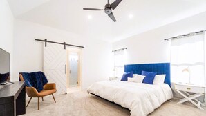 A modern bedroom with a bed, a desk, a chair, and a ceiling fan. - Chic New Build - 5 miles to Tech/Covenant/UHC - 2 miles to shopping! (Lubbock)