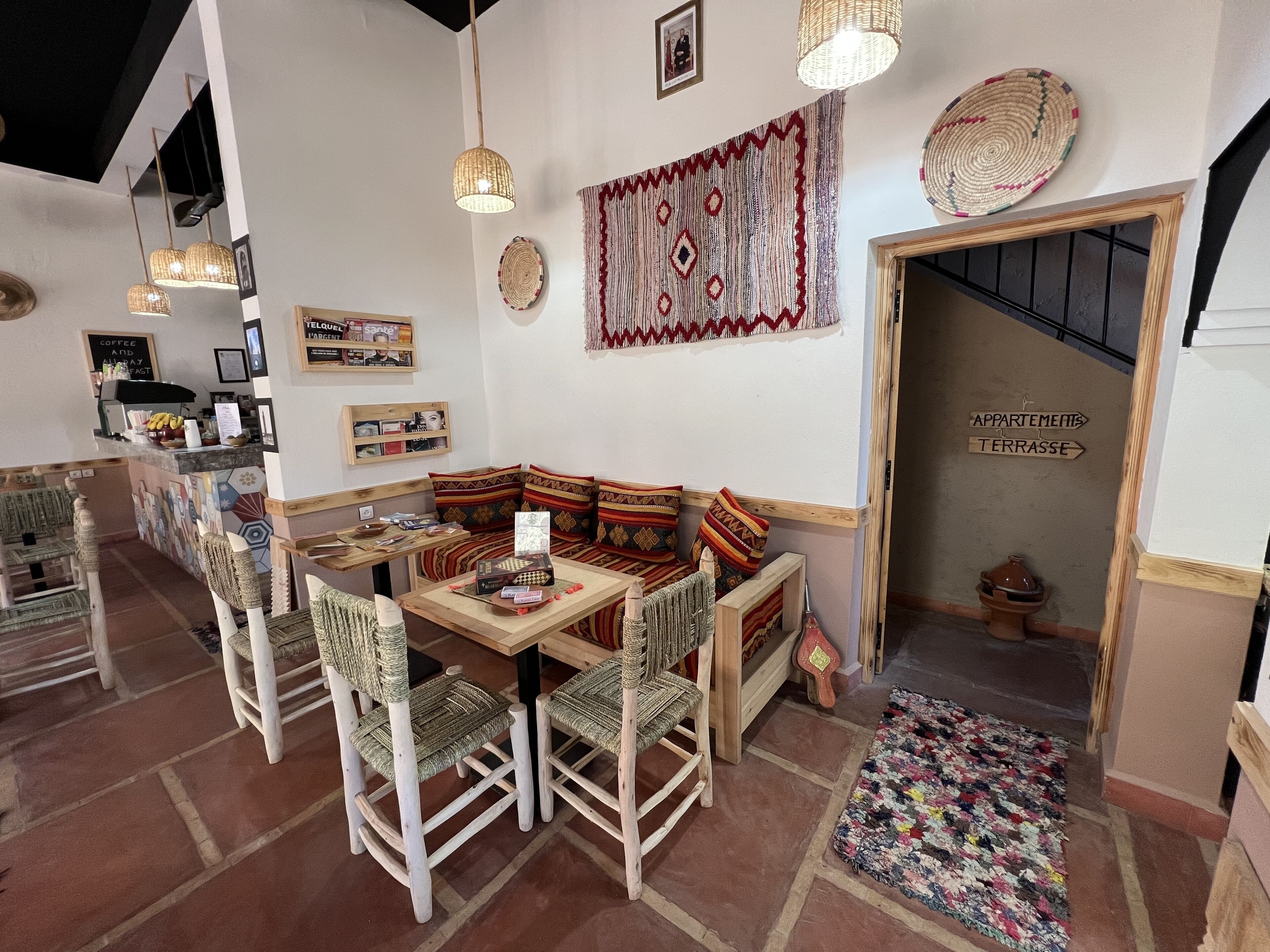 Ein gemütliches Interieur mit einer hölzernen Bank, gewebten Stühlen und einer Kaffeebar.