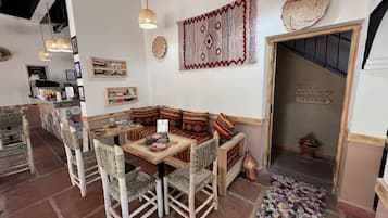 Ein gemütliches Interieur mit einer hölzernen Bank, gewebten Stühlen und einer Kaffeebar.