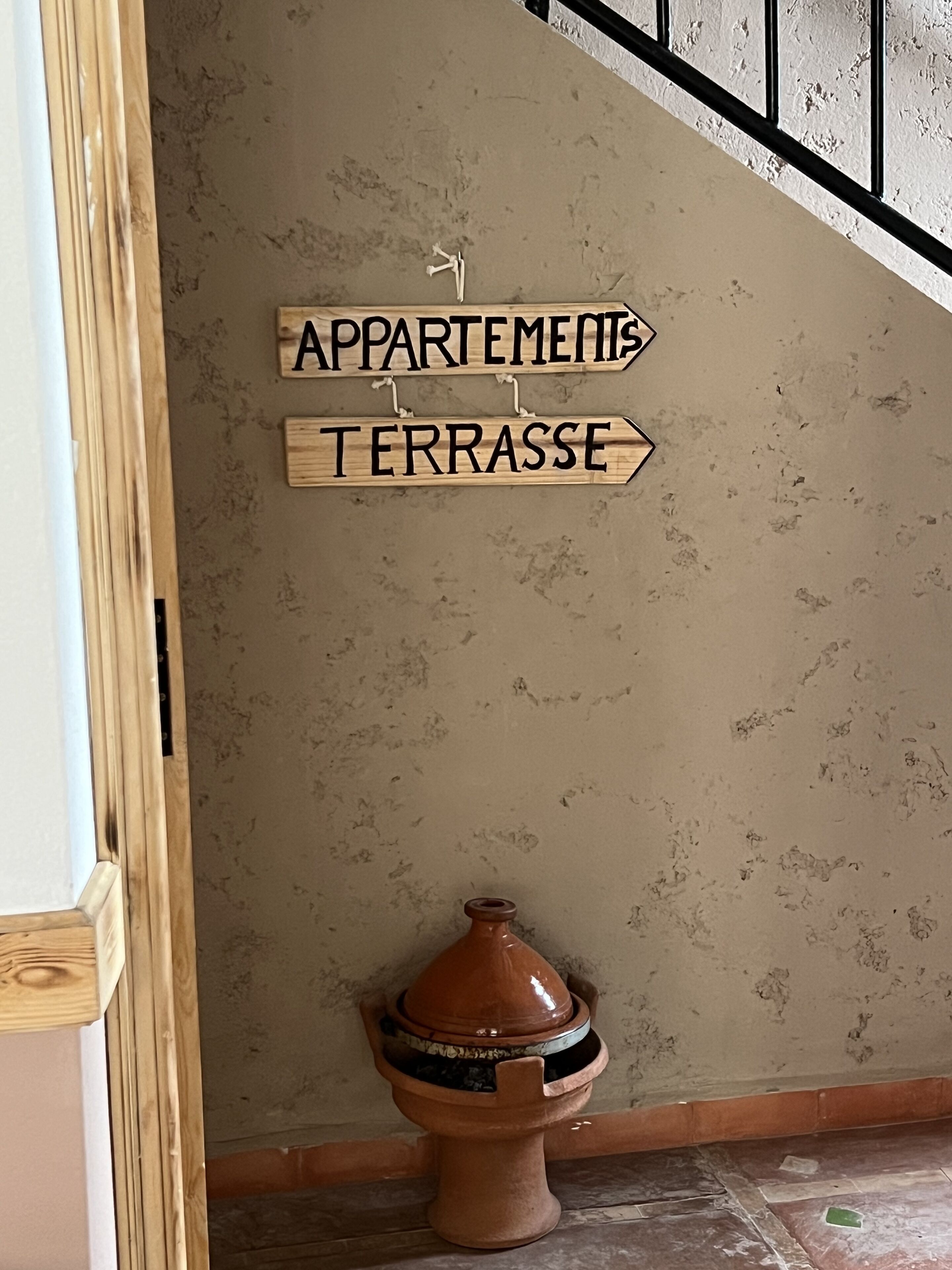 Een bord met de tekst 'APPARTMENTS' en 'TERRASSE' aan een gebouw.