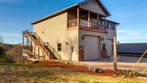 Ein zweistöckiges Haus mit Balkon, Treppe und Garage.