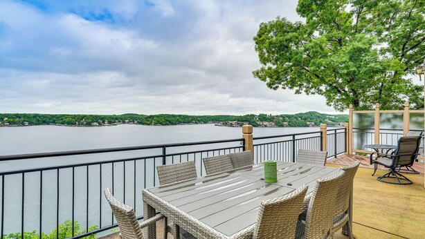 Ein Balkon mit Korbmöbeln und Blick auf einen See.