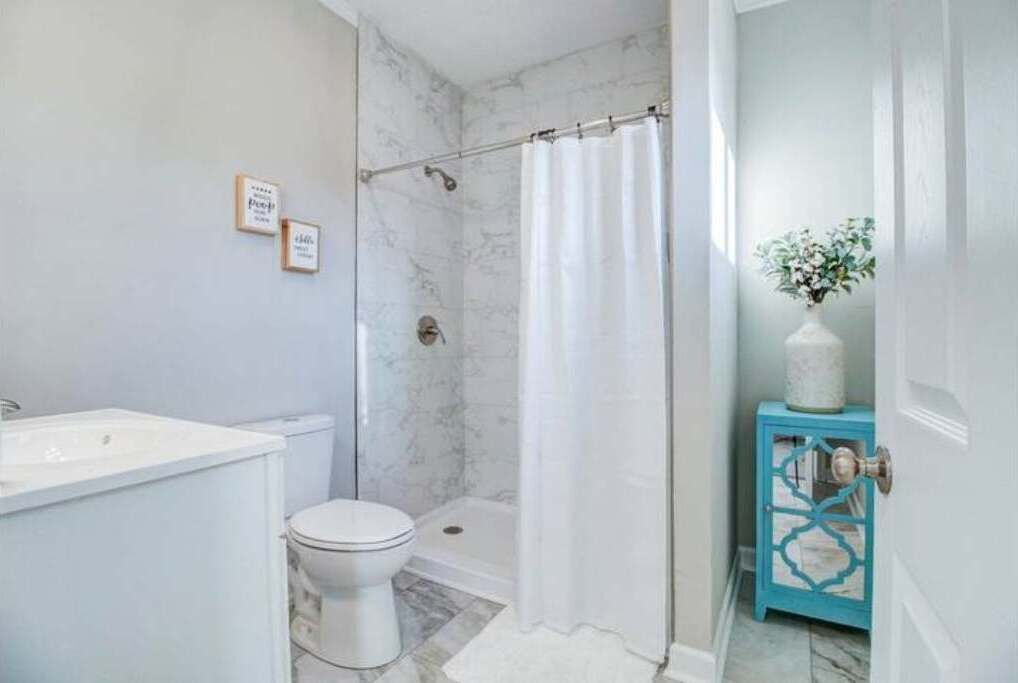 A bathroom with a shower, toilet, and sink.