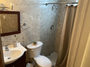 A bathroom with a sink, toilet, and shower. - Jay’s home by the beach and rainforest 
Family suite  (Luquillo)