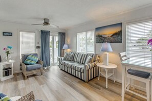 A living room with a sofa, armchair, and a small table with a lamp. - Steps to Ocean: High-End North Myrtle Beach Condo (North Myrtle Beach)
