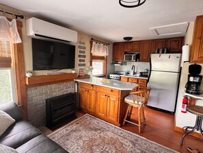 A compact kitchen with wooden cabinets, a built-in stove, a microwave, and a refrigerator.